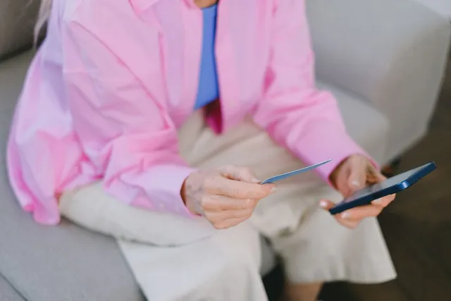 A customer shopping with a phone and payment card.
